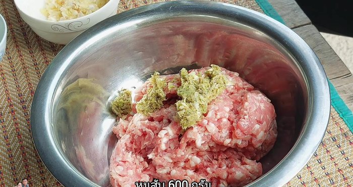 Marinate the minced pork with the pounded garlic mixture, salt, seasoning powder, sugar, white soy sauce, and 2 tablespoons of vegetable oil. Mix thoroughly and knead until tender.