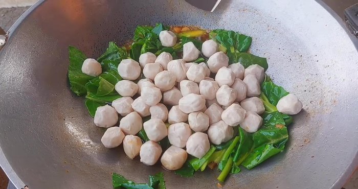 Add the pork meatballs and continue stir-frying.