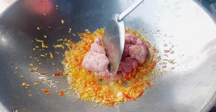 Add chopped onion and stir-fry briefly, then add the minced pork and stir-fry until cooked.