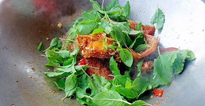 Add holy basil leaves and young chili peppers (green or red, to your preference).