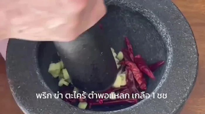 Heat oil in a pot. Sauté the curry paste until fragrant. [This step is inferred from the video and common Aom Kreuang Nai Moo preparation.]