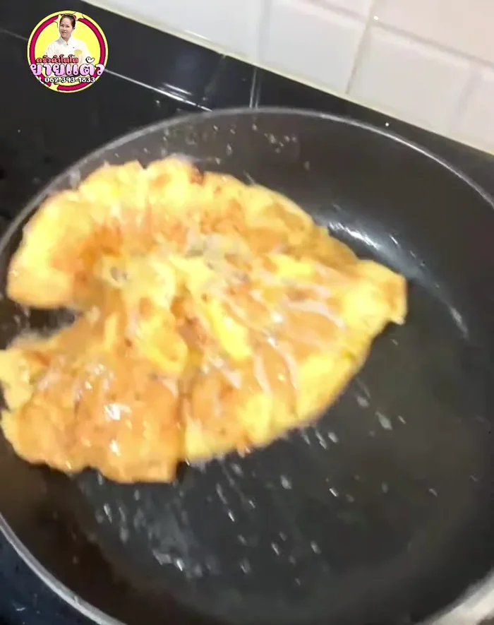 Flip the omelet and continue cooking until the fish is fully cooked.