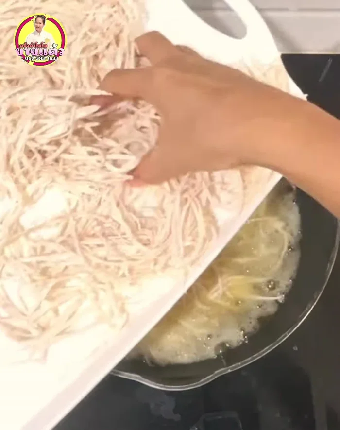 Add the grated taro to the pan. Fry over medium-low heat. After about 5 minutes, use a strainer to press the taro down ensuring all parts are submerged in the oil. (78.36, 84.32)