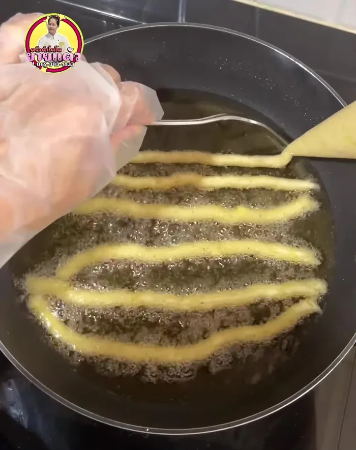 Pipe the potato mixture into the hot oil, forming sticks. Fry until golden brown, gently stirring to ensure even cooking.