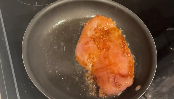 Heat oil in a pan. Add the marinated chicken and cook, sizzling until browned.