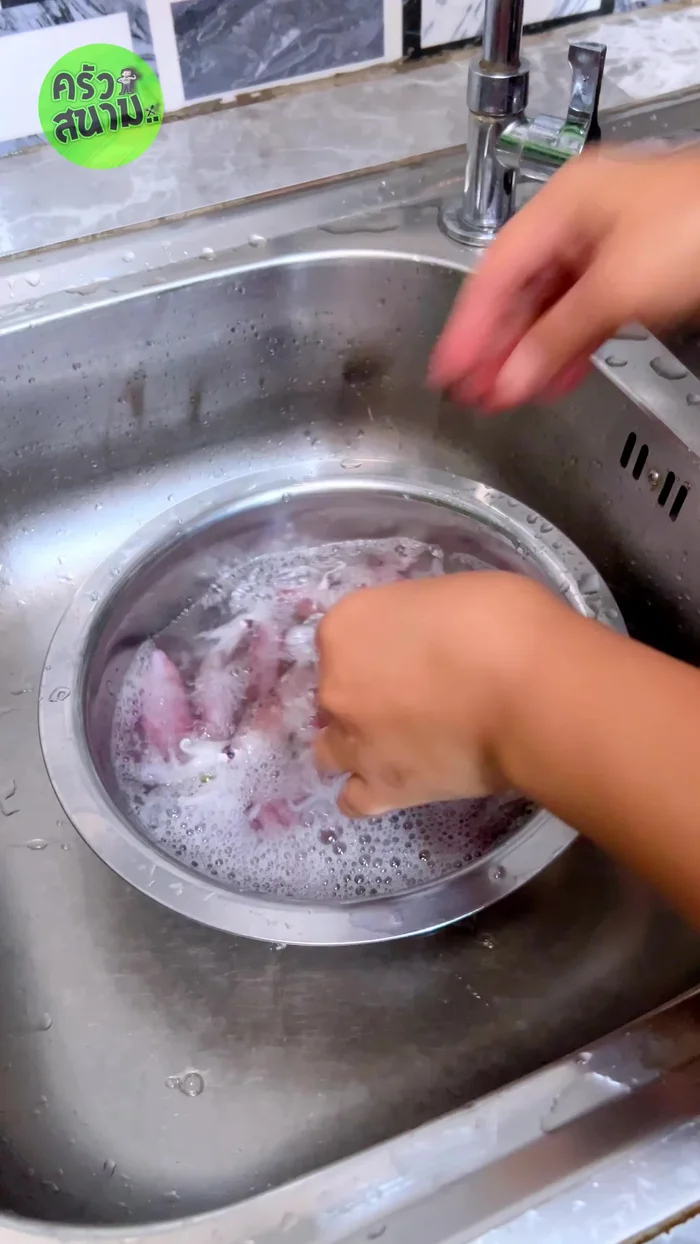 Clean the squid, carefully removing the black ink sac. This is a crucial ingredient for the stew. Score the squid.