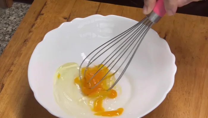 In a bowl, whisk 1 egg, add icing sugar, salt, and all-purpose flour. Mix well.