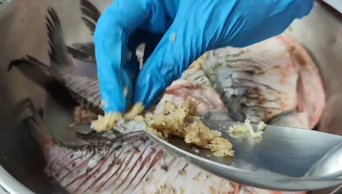 Marinate the carp with pounded garlic, pepper, fish sauce, and seasoning powder. Mix well and let it marinate for 10 minutes.