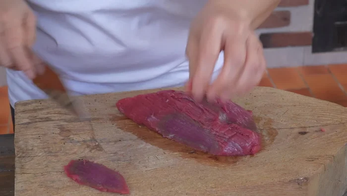 Slice beef 1/4 inch thick, against the grain. Press down to keep it firm.