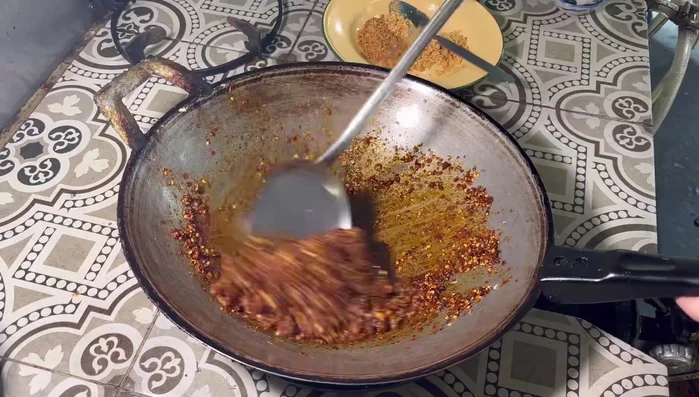 Add fried shallots and finely crushed fried garlic. Stir-fry together.