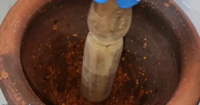 Prepare the curry paste by finely chopping dried chilies, galangal, garlic, and shallots. Pound everything together until finely ground.