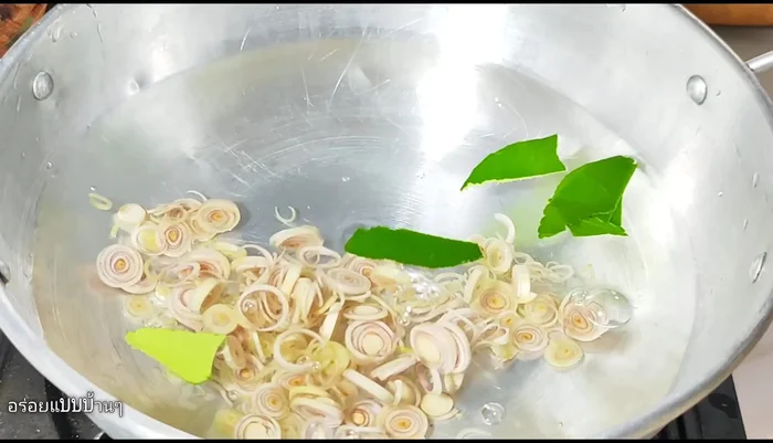 Add water to a pot on the stove, then add kaffir lime leaves and shallots. Add seasoning powder and granulated sugar.
