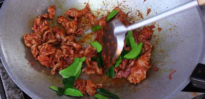 Add kaffir lime leaves to enhance aroma and remove meaty odor. Stir-fry until the leaves are fragrant.