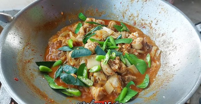 Add kaffir lime leaves and chili peppers. Stir-fry until everything is cooked through.