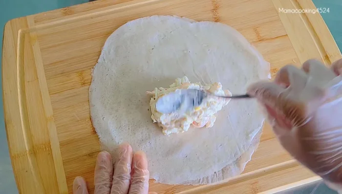 Spoon the cream cheese mixture onto the spring roll sheets.