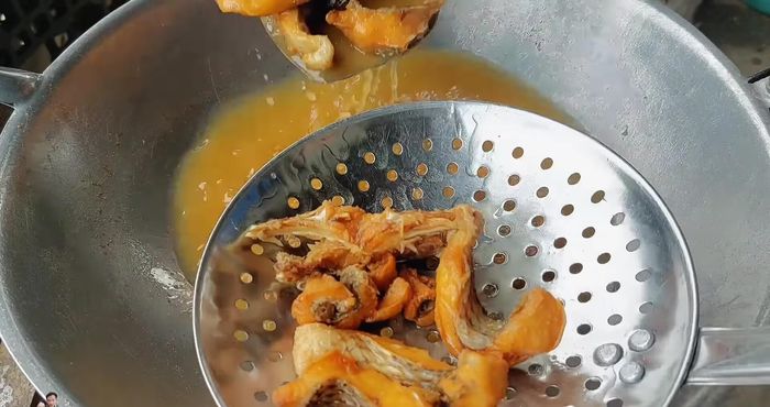 Remove the fried fish and set aside in a colander to drain excess oil.