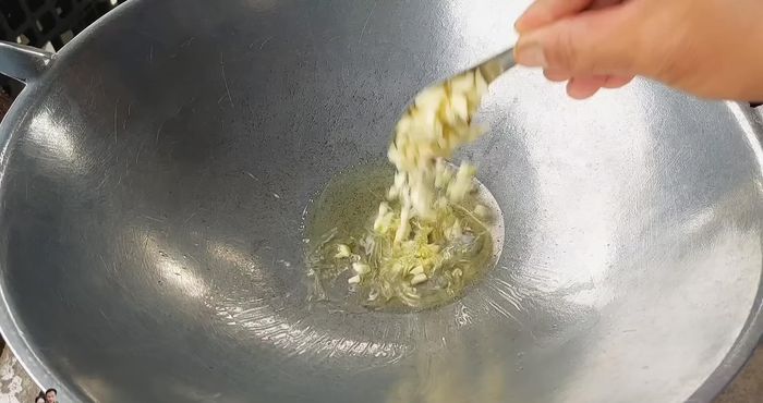 In the same pan, add a little vegetable oil, then add 20 grams of chopped garlic and stir-fry until fragrant.