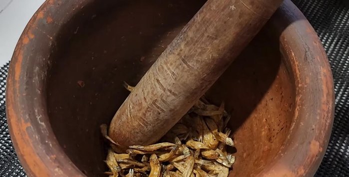 Add the fried fish and continue pounding, not too finely.