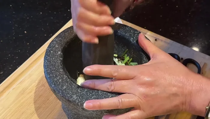 Crush garlic, black peppercorns, and cilantro stems.
