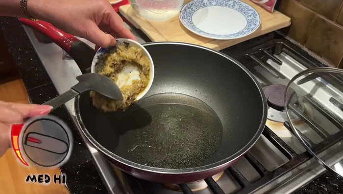 Heat cooking oil in a pot over medium-high heat. Add crushed garlic and palm sugar; stir-fry until garlic is slightly yellow.