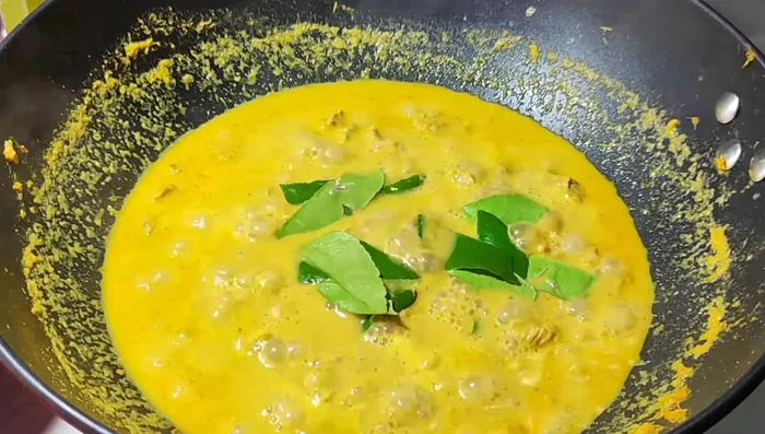 Add the blanched bamboo shoots and kaffir lime leaves to the curry.