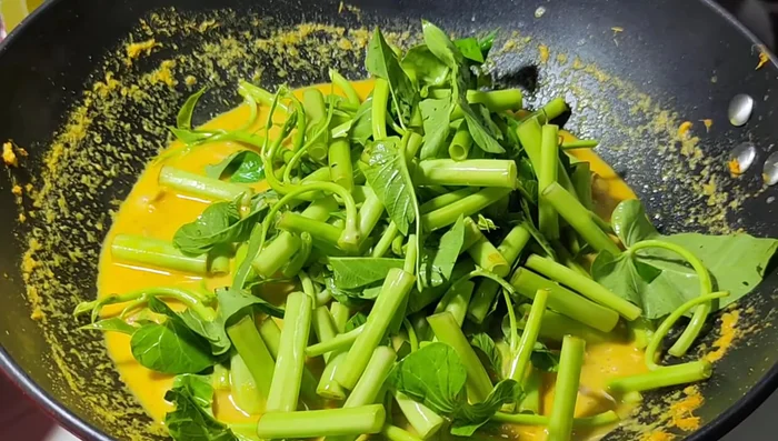 Add the morning glory and stir gently; avoid overcooking.