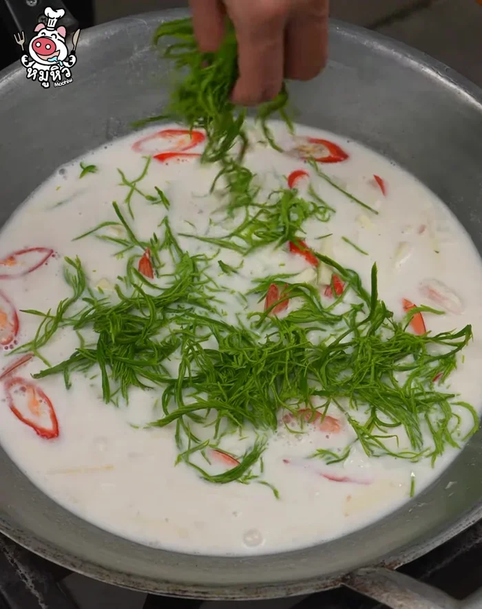 Add cha-om leaves and stir. Cook until shrimp is done.