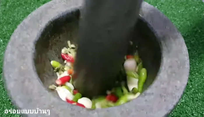Finely pound garlic, chili, and coriander root in a mortar.