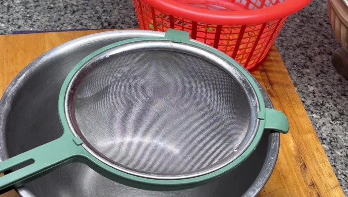 Pour the blended mixture through a fine sieve or strainer, pressing to extract as much juice as possible.