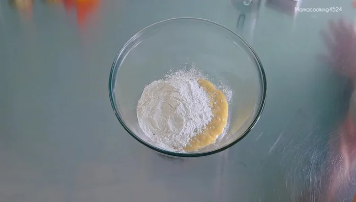 Add glutinous rice flour and tapioca flour to the mashed bananas.