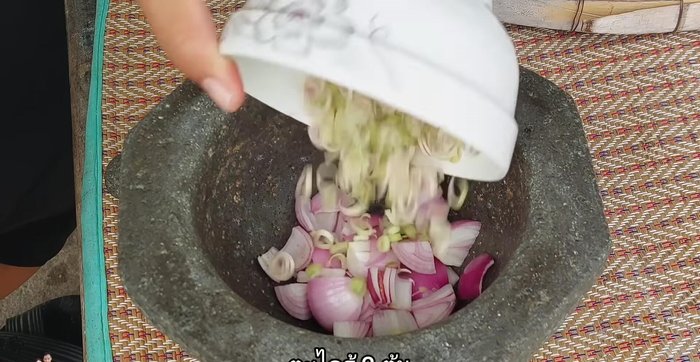 Pound the curry paste: shallots, lemongrass, garlic, and chilies (green and red) together.