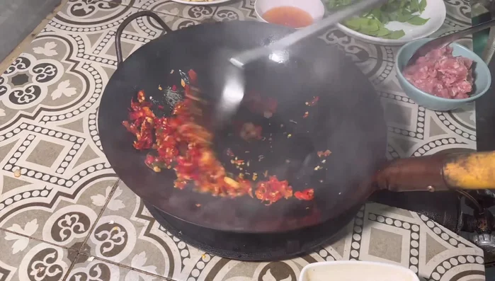 Add the pounded chili and garlic mixture to the pan and stir-fry for a while.