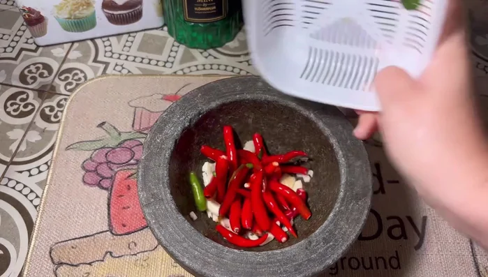 Pound the curry paste, garlic, red chili, and dried chili together in a mortar and pestle until well blended. Set aside.
