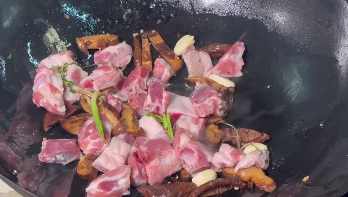 Add the pork bones and stir-fry continuously until slightly browned.