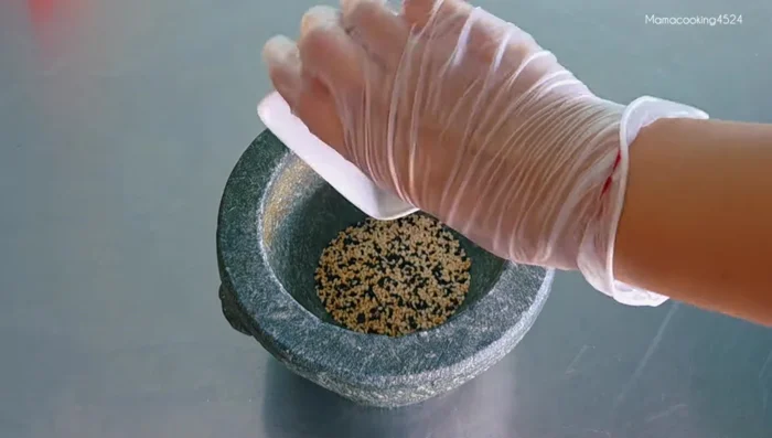 Pound the cooled sesame seeds using a circular motion until slightly separated.