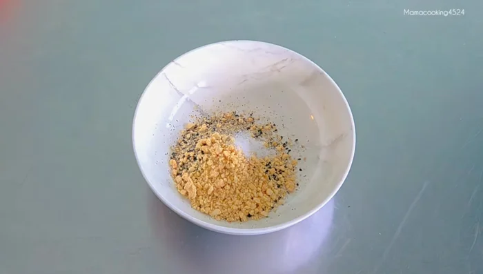 Mix the pounded sesame seeds with ground peanuts, salt, water, and sugar.