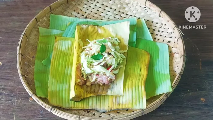 Wrap the chicken mixture in banana leaves, decorating the surface with shredded kaffir lime leaves and chili peppers.