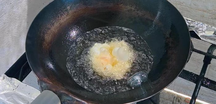 Heat vegetable oil in a pan. Crack eggs into the hot pan. Avoid flipping; use a spoon to gently pour oil over the top of the eggs until they turn golden yellow and crispy.