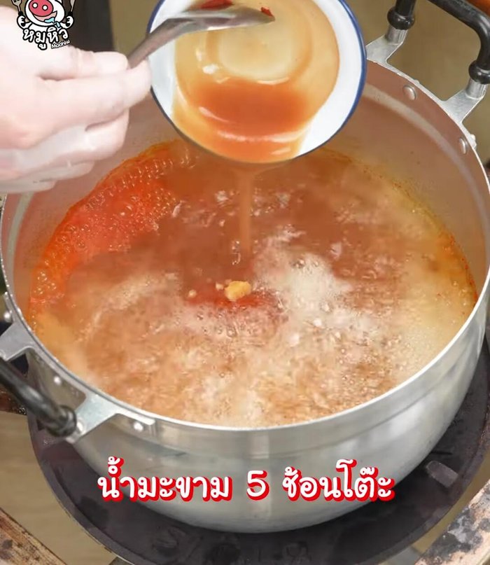 Add ingredients to curry: Add carrots and shrimp to the boiling curry.