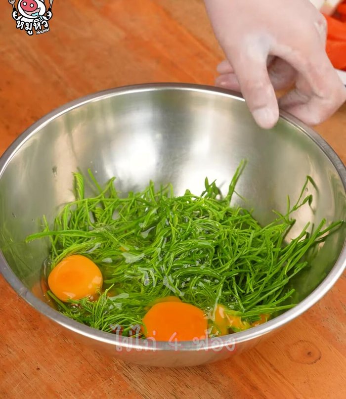 Make the Cha-om omelet: Crack eggs into a bowl, whisk, and add chopped Cha-om. Heat oil in a pan, add the egg mixture, and fry until cooked. Remove, let cool, and cut into bite-sized pieces.