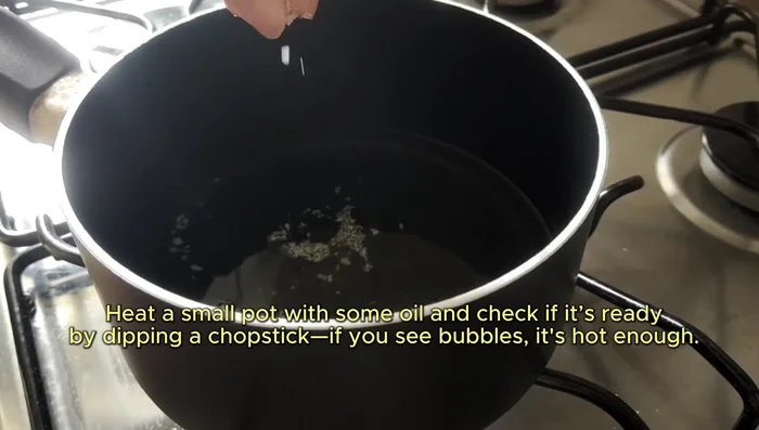 Heat oil in a small pot. Test if it's hot enough with a chopstick (bubbles) or a breadcrumb. Pan-fry the shrimp cakes, using less oil if possible. If not fully submerged, spin hot oil over them for even cooking.