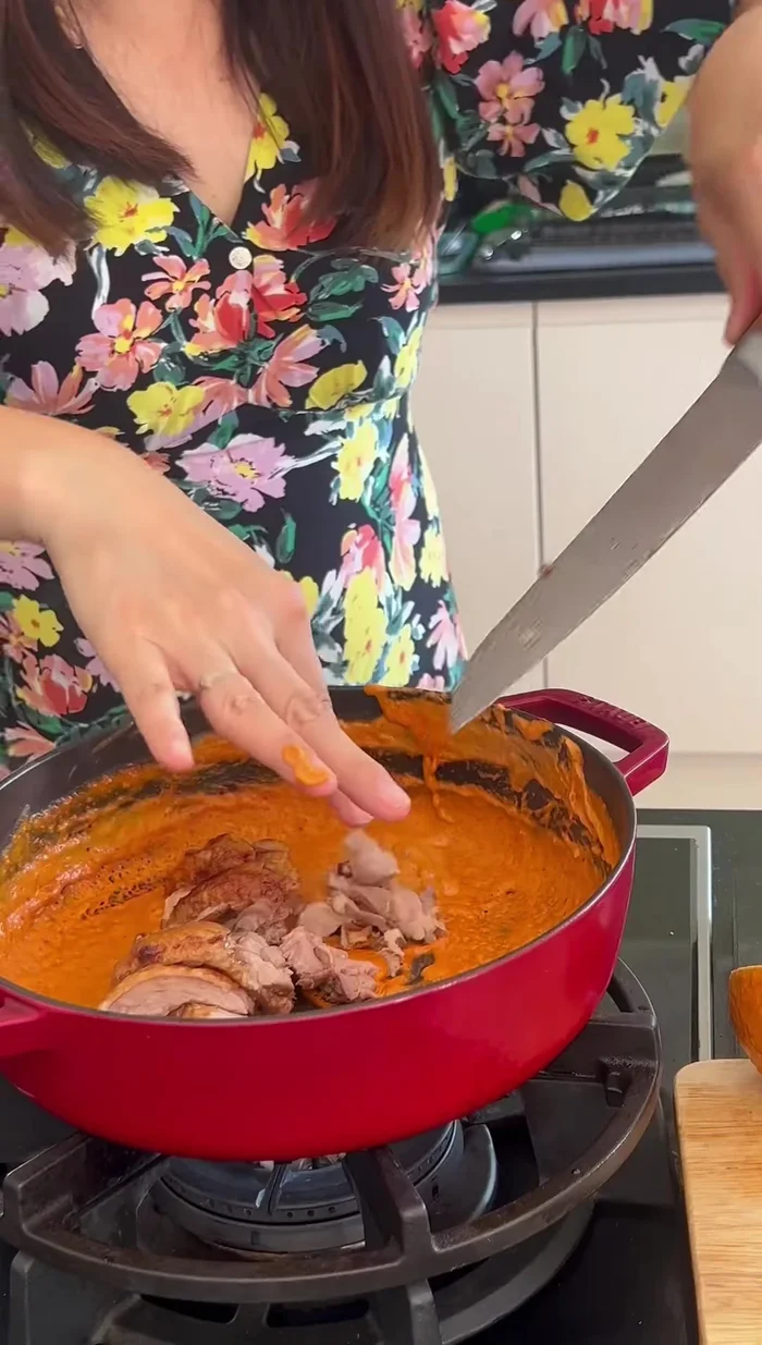 Add the roasted duck, baby tomatoes, and some coconut milk to the curry. Mix well.