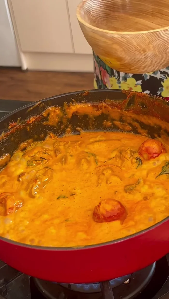 Serve the duck red curry with garnish of kaffir lime leaves, Thai basil and red chilies, alongside fluffy jasmine rice.