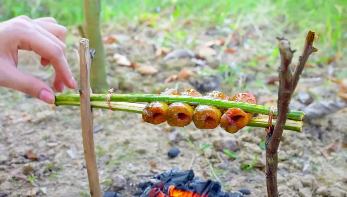 Grill the eel in the bamboo tubes, brushing with sauce.