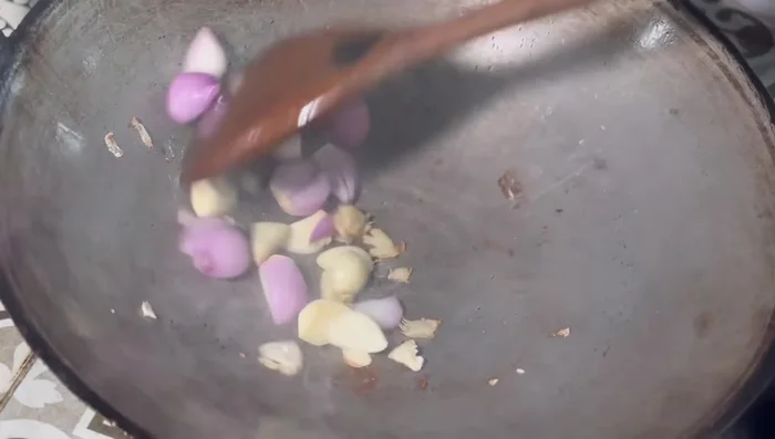 In a pan, fry garlic, shallots, and chili with a little galangal to remove any fishy smell.