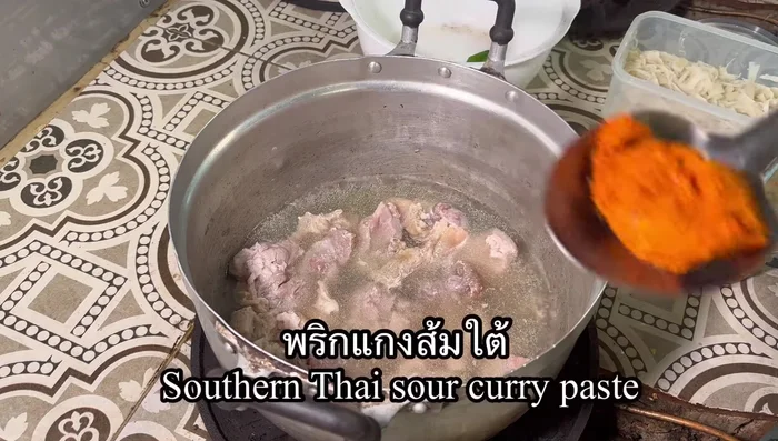 Once tender, add about half a large ladle of red curry paste, stirring slowly to incorporate.