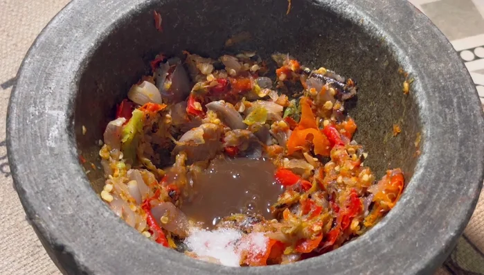 Add MSG, fish sauce, and Kolekole to the pounded chili mixture to make chili paste.