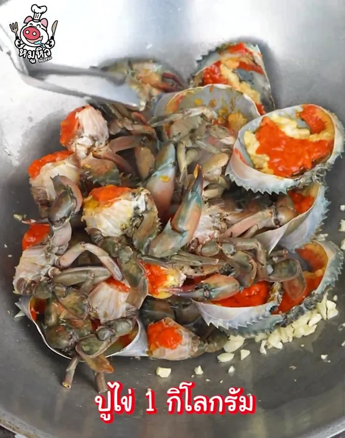 Add the cleaned and cut crab and crab eggs to the pan. Stir-fry with a little garlic and add water.