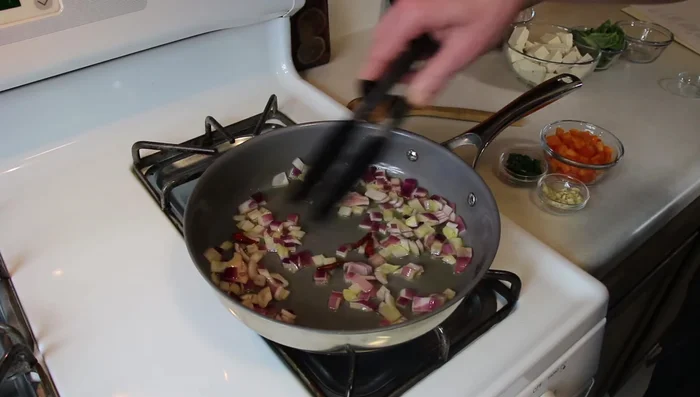 Add bird's eye chilies and diced peppers to the pan. Cook briefly.