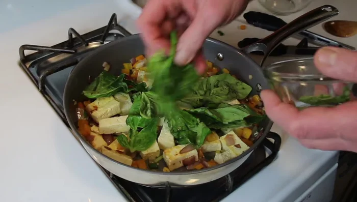 Add the fresh basil leaves (remove large stems). Stir gently.